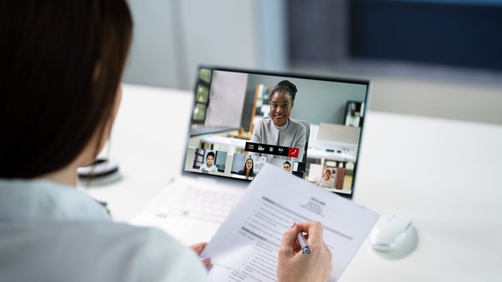 Small business owner reviewing AI-screened résumés on a laptop