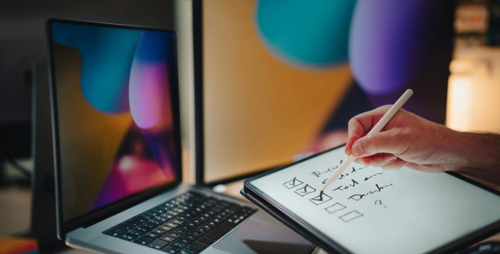 Digital checklist on tablet in a modern creative workspace with AI tools and laptop screens in the background