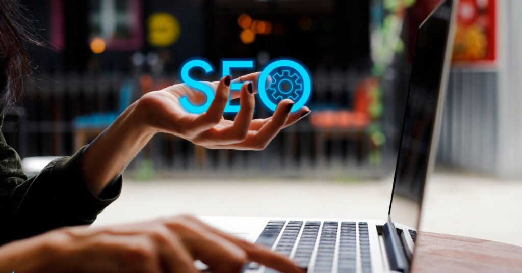 Concept image of AI-powered SEO automation with a hand holding SEO gear icon in front of laptop – Frase vs Scalenut tools