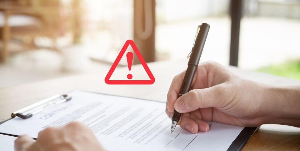 Person signing a document with warning symbol – cautionary image for risky AI tool terms and hidden agreements