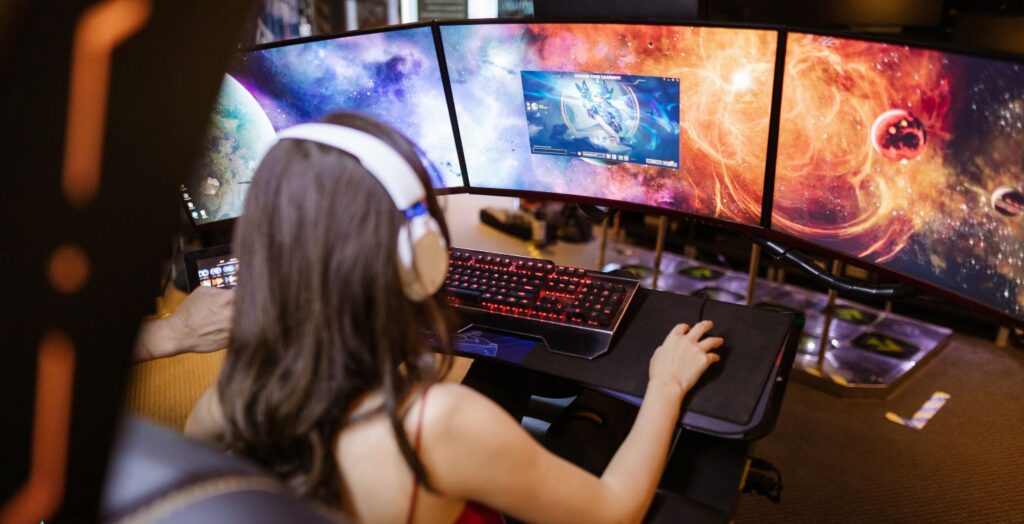 Creator using AI video generator in a futuristic gaming setup with triple-screen display in 2025