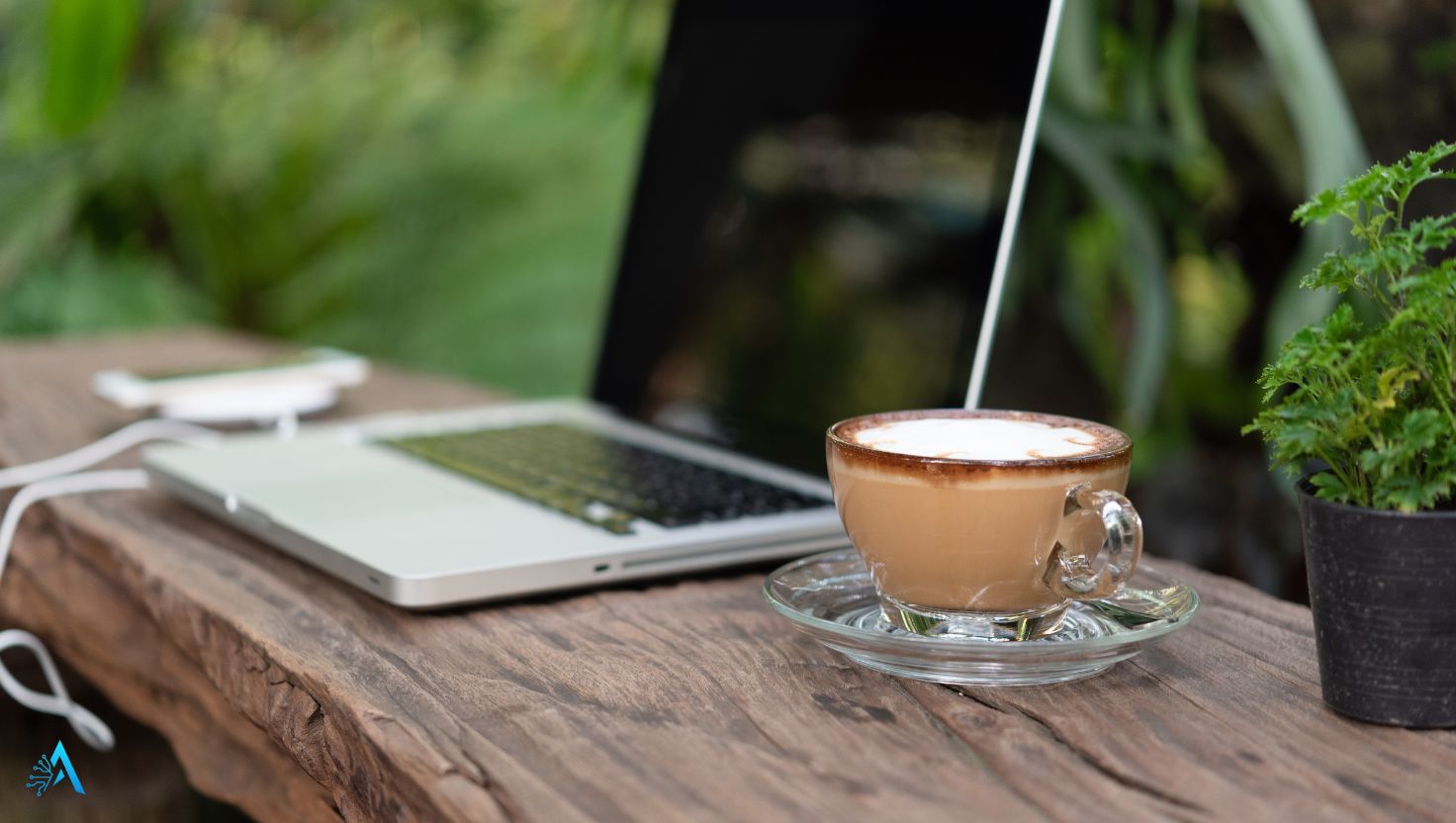 Laptop and coffee on an outdoor table, set up for offline AI while traveling
